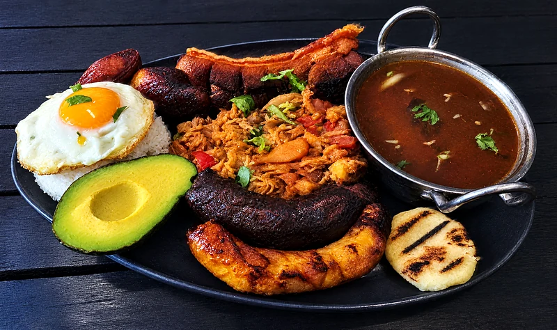Bandeja paisa at Tentaciones: beans, rice, chicharron, chorizo, plantain, fried egg and arepa on one plate